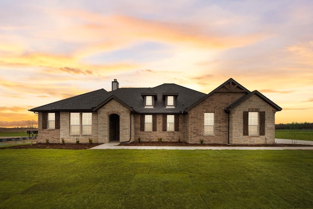 french country inspired facade with a yard