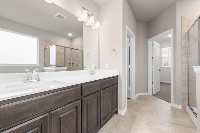 bathroom featuring tile patterned floors, vanity, and a shower with door