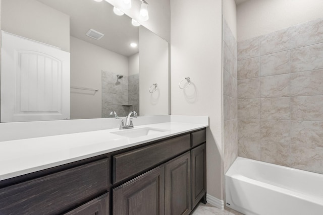 bathroom featuring tiled shower / bath combo and vanity