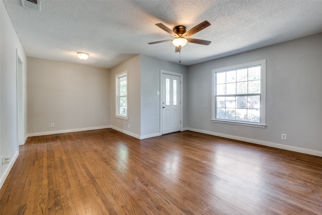 empty room featuring a textured ceiling, ceiling fan, and wood-type flooring