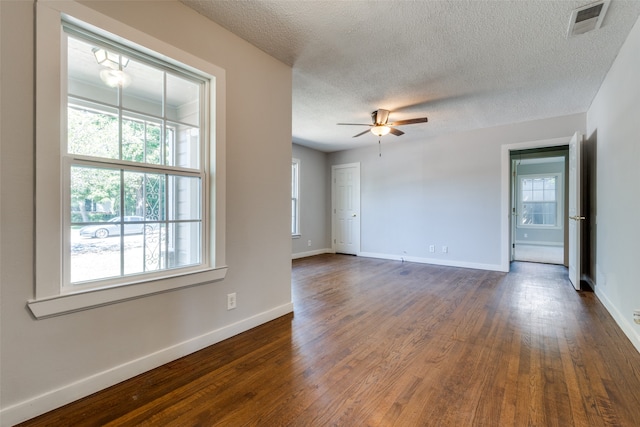 empty room with dark hardwood / wood-style flooring, ceiling fan, and a textured ceiling