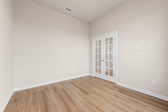 spare room with light hardwood / wood-style flooring and french doors