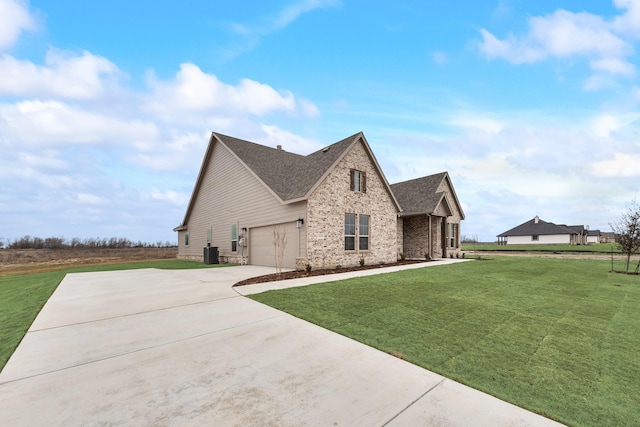 view of home's exterior featuring a garage, a yard, and central AC