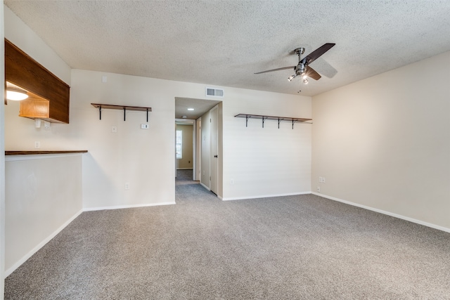 unfurnished living room featuring ceiling fan, a textured ceiling, and carpet