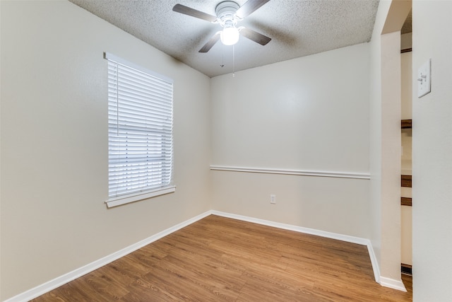 spare room with a textured ceiling, ceiling fan, and light hardwood / wood-style flooring