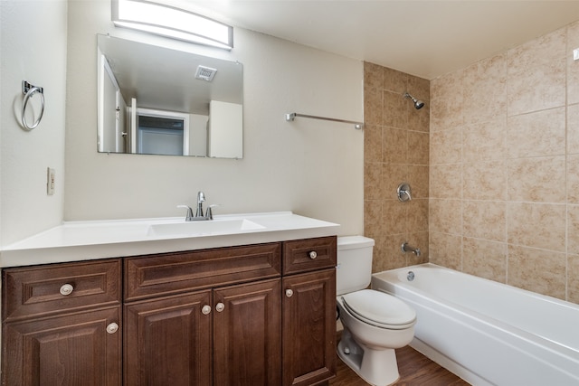 full bathroom featuring vanity, tiled shower / bath combo, toilet, and hardwood / wood-style flooring