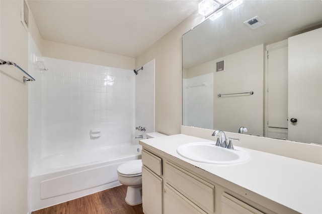 full bathroom with wood-type flooring, vanity, tiled shower / bath combo, and toilet