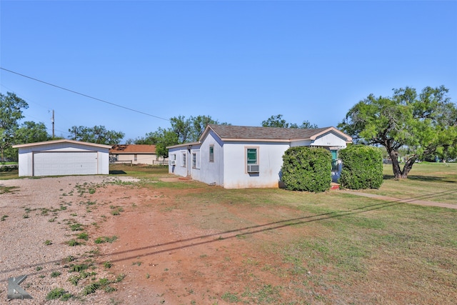 exterior space featuring a garage, an outbuilding, and a yard