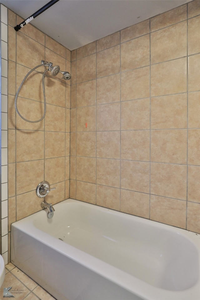 bathroom with tile patterned floors, toilet, and tiled shower / bath combo