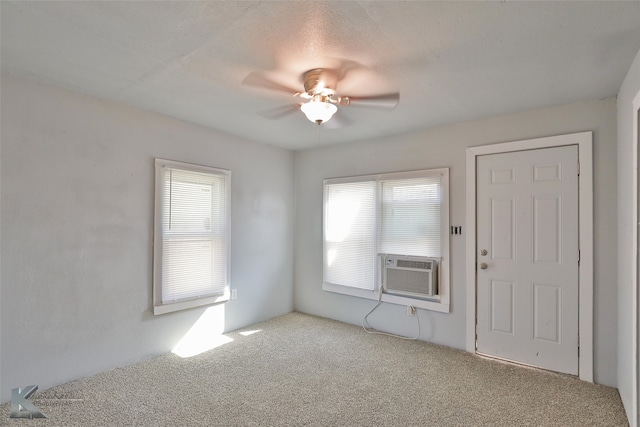 spare room featuring ceiling fan, light colored carpet, a textured ceiling, and cooling unit