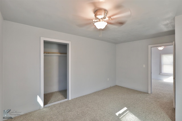 unfurnished bedroom featuring ceiling fan, a closet, and light colored carpet