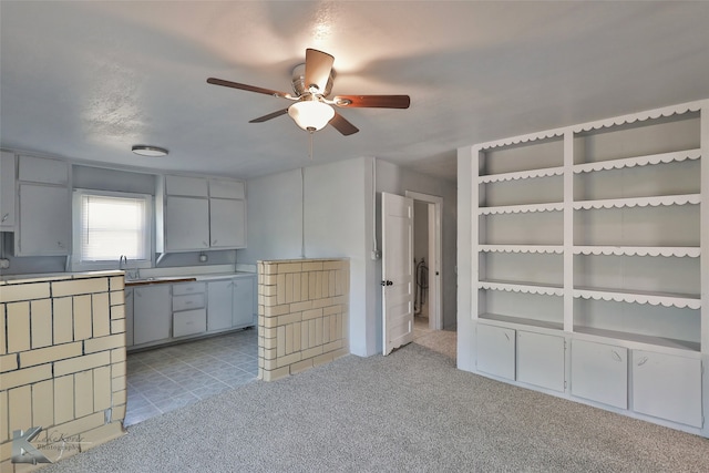 kitchen featuring ceiling fan, light colored carpet, and a textured ceiling