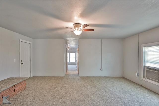 unfurnished room featuring a wealth of natural light, ceiling fan, a textured ceiling, and carpet floors