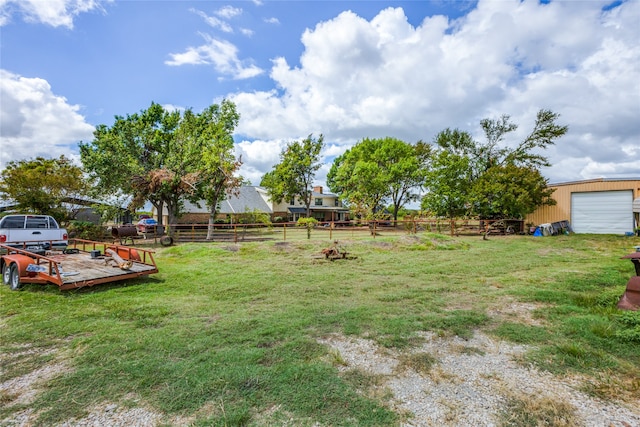 view of yard featuring a garage and an outbuilding