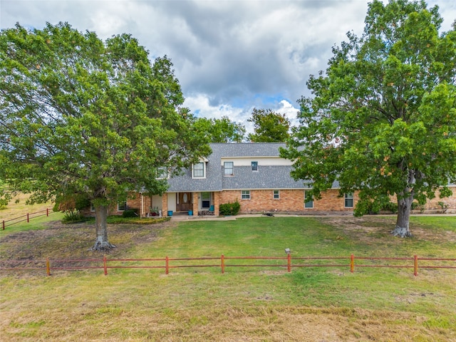 back of house featuring a lawn and a rural view