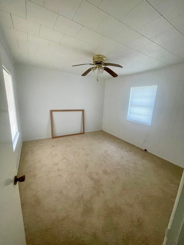 carpeted spare room with a healthy amount of sunlight and ceiling fan