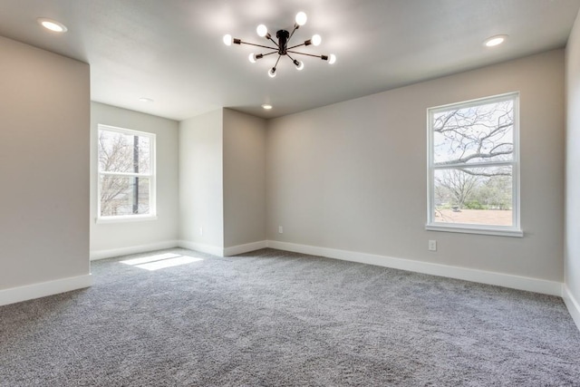 spare room with carpet and an inviting chandelier