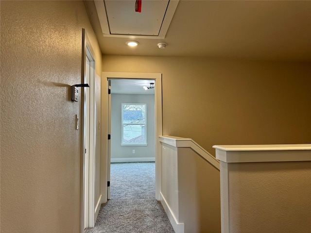 hall with light colored carpet