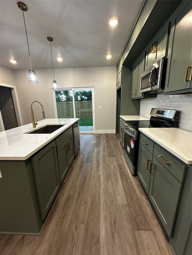 kitchen with hanging light fixtures, light stone counters, dark hardwood / wood-style flooring, stainless steel appliances, and sink