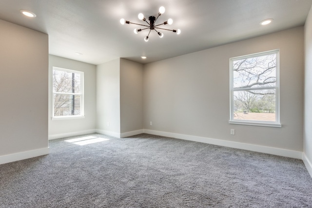 unfurnished room featuring an inviting chandelier and carpet flooring