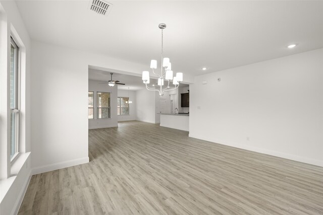 kitchen with light stone counters, a center island with sink, white cabinetry, stainless steel appliances, and light hardwood / wood-style floors