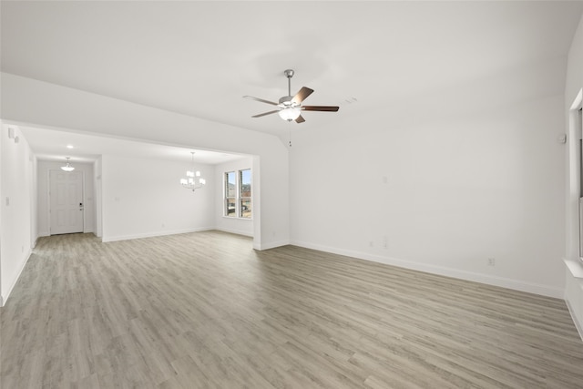 unfurnished living room featuring ceiling fan with notable chandelier and light wood-type flooring