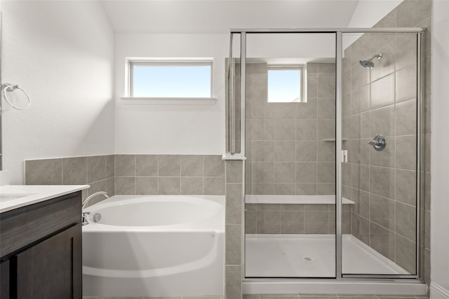 bathroom featuring vanity, a healthy amount of sunlight, and separate shower and tub