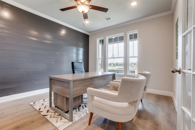 home office with ceiling fan, light hardwood / wood-style flooring, crown molding, and wood walls