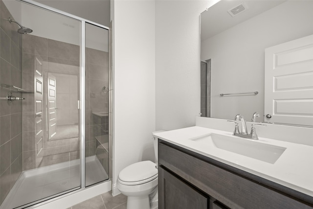 bathroom featuring vanity, toilet, tile patterned flooring, and a shower with door