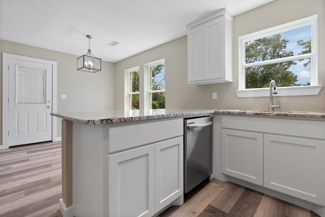 kitchen featuring light hardwood / wood-style flooring, hanging light fixtures, kitchen peninsula, and white cabinetry