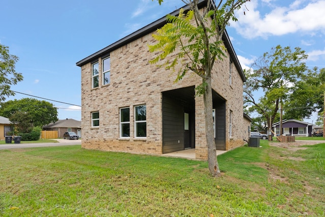 back of property with a yard and central AC