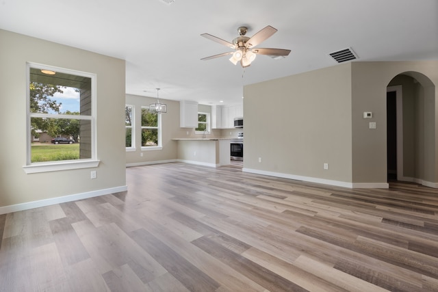 unfurnished living room with light hardwood / wood-style flooring, ceiling fan, and sink