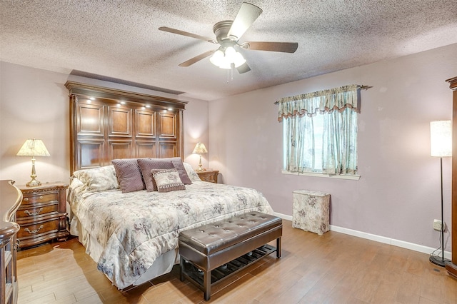 bedroom featuring ceiling fan, a textured ceiling, and light hardwood / wood-style flooring