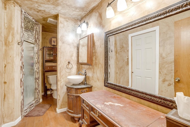 bathroom featuring vanity, toilet, hardwood / wood-style floors, and an enclosed shower