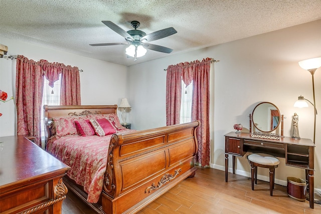 bedroom featuring a textured ceiling, wood-type flooring, and ceiling fan