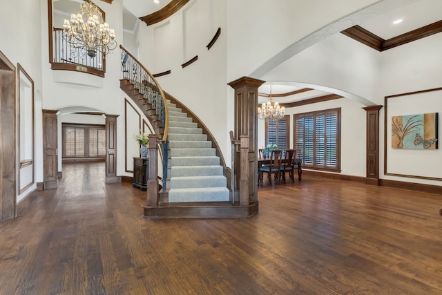 entrance foyer featuring a healthy amount of sunlight, a towering ceiling, and dark wood-type flooring