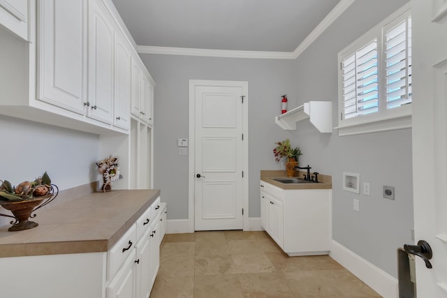 laundry room with cabinets, hookup for a washing machine, crown molding, electric dryer hookup, and sink