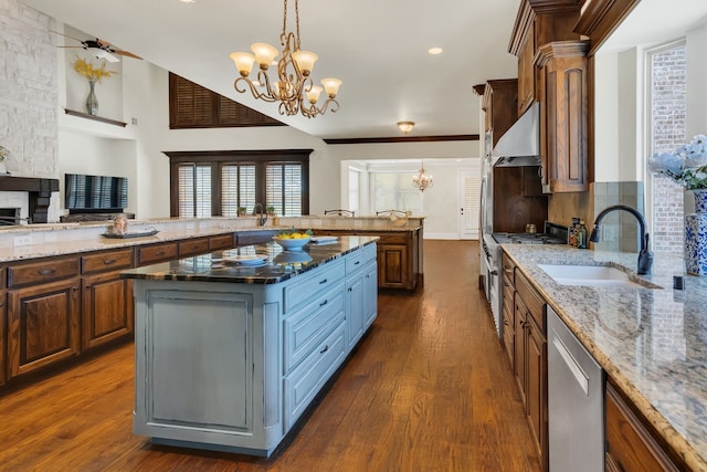 kitchen featuring a kitchen island, stainless steel appliances, exhaust hood, and dark stone counters