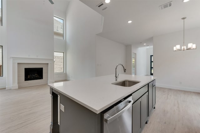 kitchen with decorative light fixtures, stainless steel dishwasher, sink, and a healthy amount of sunlight