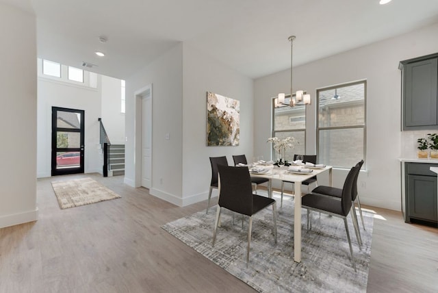 dining room featuring light wood-type flooring and a chandelier