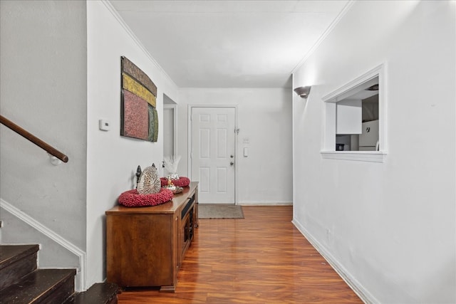 hallway with ornamental molding and hardwood / wood-style floors