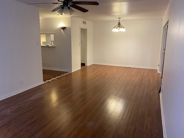 spare room with ceiling fan with notable chandelier, dark wood-type flooring, and crown molding