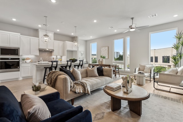 living room with ceiling fan and light hardwood / wood-style floors