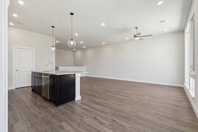 kitchen featuring visible vents, an island with sink, open floor plan, wood finished floors, and a sink