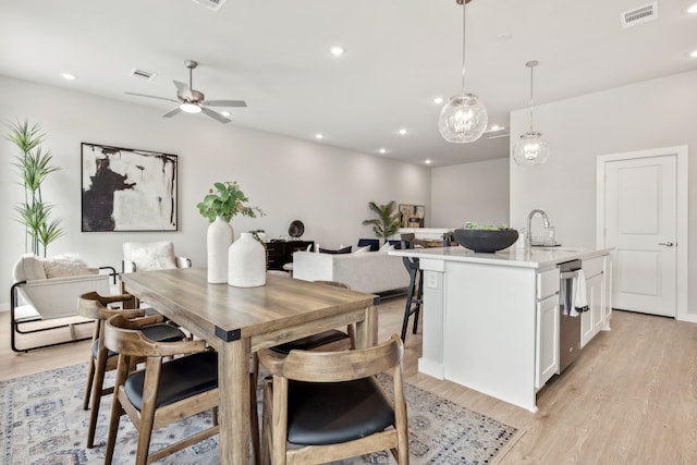 dining area with ceiling fan, sink, and light hardwood / wood-style floors