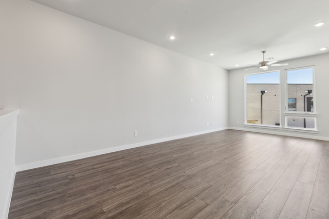 empty room with a ceiling fan, baseboards, dark wood-type flooring, and recessed lighting