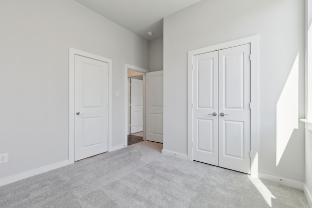 unfurnished bedroom with carpet, baseboards, and a closet