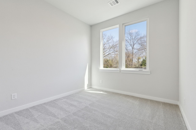 carpeted spare room featuring visible vents and baseboards