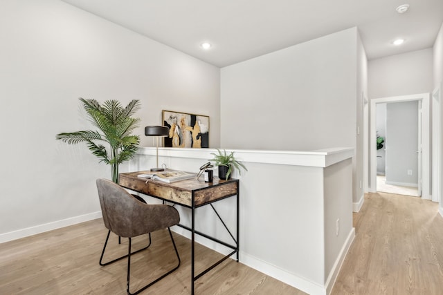 home office with light hardwood / wood-style flooring