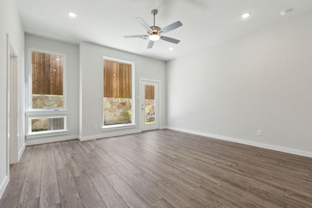 unfurnished room featuring recessed lighting, wood finished floors, and baseboards